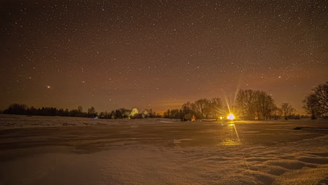 Timelapse-Of-Starry-Night-View-From-Frozen-Landscape-With-Lights-Of-Building-In-Background