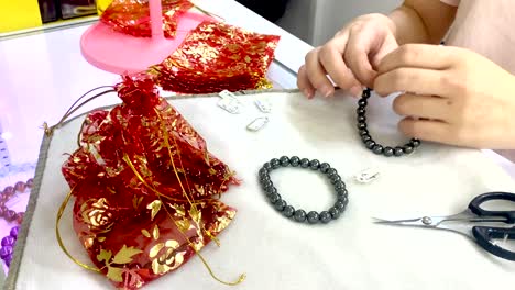 Woman-hands-packing-hematite-stone-into-red-packets