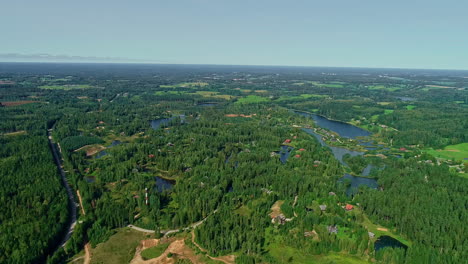 Waterfront-homes-by-lakes-in-a-picturesque-forest---high-altitude-aerial-view