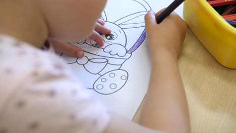 little-girl-colouring-adorable-bunny-in-children-book-learning-precision,-slow-motion