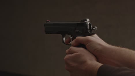 Hand-pulling-back-hammer-of-9mm-pistol-and-firing-a-bullet