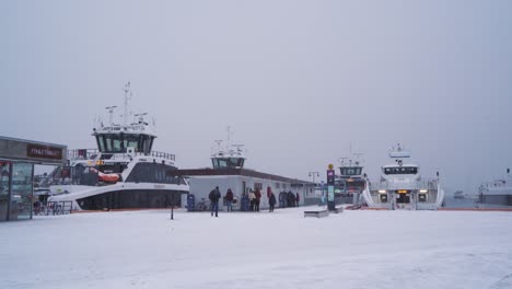 Blick-Auf-Die-Passagiere,-Die-Sich-Auf-Den-Weg-Machen,-Ein-Boot-Am-Pier-Von-Aker-Brygge-Mit-Starkem-Schneefall-Zu-Besteigen