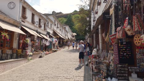 People-walking-through-market-streets-in-Gjirokaster,-Albania