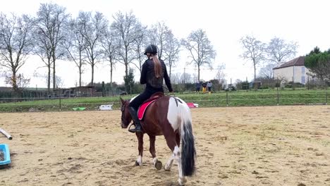 Female-jockey-riding-her-pony-in-the-paddock