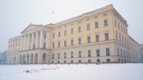 The-Royal-Palace-In-Oslo-With-Heavy-Snow-Falling-Seen-From-The-Palace-Park-Grounds-Covered-In-Snow
