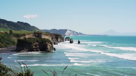 Vista-Pintoresca-De-Olas-Espumosas-En-La-Playa-De-Tres-Hermanas-Y-Roca-Elefante-En-Taranaki,-Nueva-Zelanda