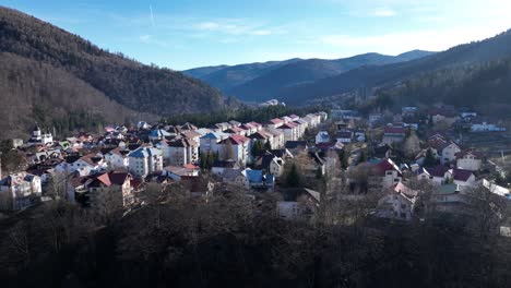Luftvorwärtsflug-über-Der-Stadt-Sinaia-Zwischen-Grünen-Bergen-Rumäniens-An-Sonnigen-Tagen