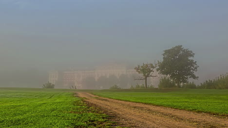 Timelapse-shot-of-path-leading-to-Jelgava-Castle-in-Latvia,-surrounded-by-heavy-fog-on-a-foggy-morning