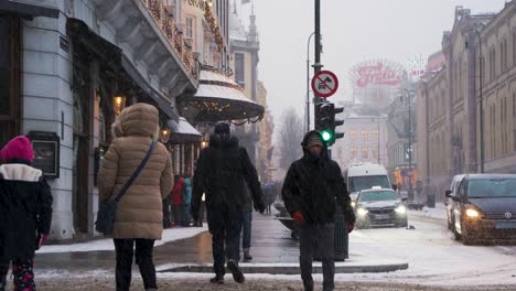 Family-Waiting-To-Cross-Road-At-Karl-Johans-Gate-Road-During-Heavy-Snow-Fall-In-Oslo,-Norway