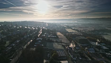 Cold-winter-aerial-footage-of-a-town-city-landscape,-with-low-afternoon-lighting-and-freezing-sunlit-houses