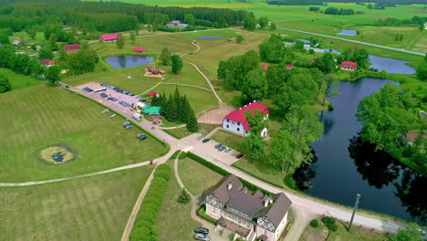 Recreational-building-near-lakes-and-river-in-vibrant-Europe-landscape,-aerial