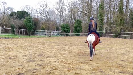 Female-jockey-riding-her-pony-in-the-paddock