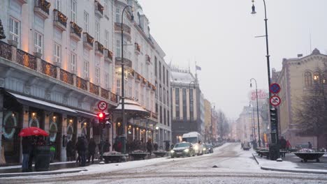 Pedestrians-Crossing-Karl-Johans-Gate-Road-During-Snowfall-In-Oslo