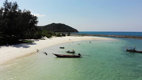 Flying-with-Drone-over-sandy-beach-and-tourists-at-Ao-Chaloklum-Bay-in-Koh-Phangan,-Thailand