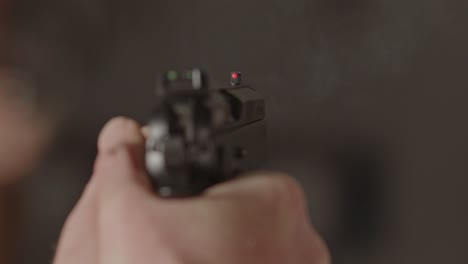 Overshoulder-of-9mm-pistol-being-fired-and-a-casing-being-ejected-in-slow-motion