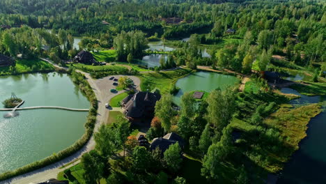 Luxury-estate-surrounded-by-lakes-and-forest,-aerial-orbit-view