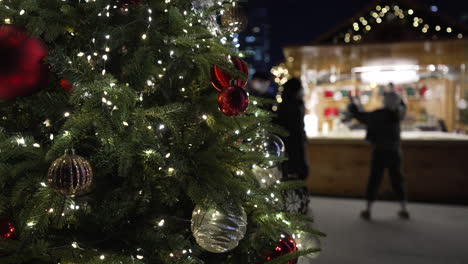 Luces-Brillantes-De-Un-árbol-De-Navidad-Con-Gente-Paseando-Por-El-Bazar-Navideño-Del-Mercado-De-La-Plaza-Gwanghwamun-En-Seúl,-Corea-Del-Sur