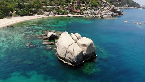Guy-jumps-from-a-big-Rock-into-the-Sea,-Tanote-Bay-Beach,-Koh-Tao,-Thailand