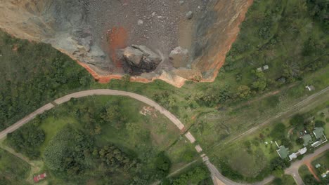 Aerial:-Precipitous-edge-of-open-pit-mine-growing-close-to-closed-road