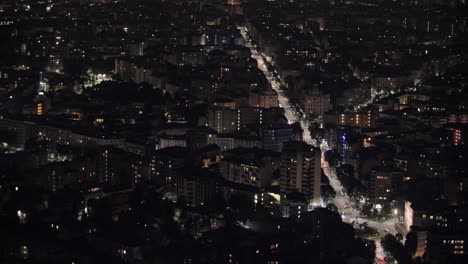 City-traffic-and-buildings-lights-of-night-Milan,-aerial-view