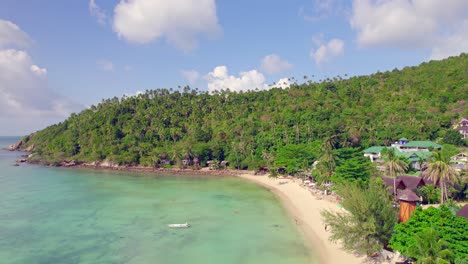4k-Aerial-Drone-Down-and-Forward-Shot-of-Salad-Beach-on-Koh-Phangan-in-Thailand-with-Fishing-Boats,-Teal-Water,-Coral,-and-Green-Jungles