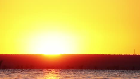 Schöne-Warme-Farben-Des-Sonnenaufgangs-über-Ruhigem-Wasser
