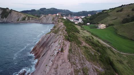 Couple-alone-embracing-each-other-on-the-cliffs-of-northern-Spain,-Zumaia
