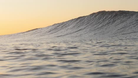 A-beautiful-wave-breaks-as-the-sun-rises-in-the-background
