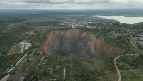 Rising-aerial-peers-down-into-big-hole-open-pit-of-diamond-mine-in-ZA