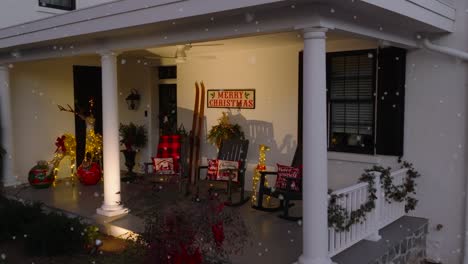 Merry-Christmas-sign-and-holiday-decorations-on-front-porch-of-American-home-during-winter-snow