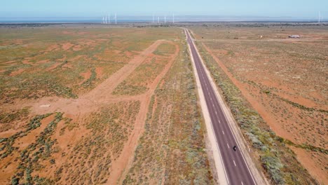 Aerial-drone-landscape-pan-shot-of-motorbike-on-freeway-highway-outback-wind-farm-country-road-tourism-travel-Port-Augusta-Adelaide-South-Australia-4K