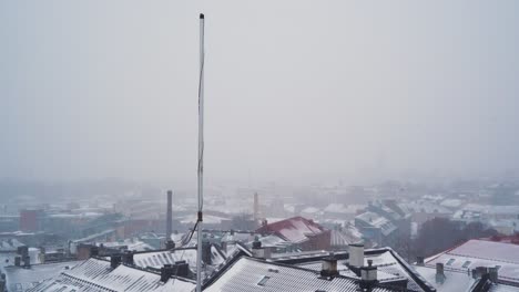 Tall-Pole-Above-Snow-Covered-Roof-In-St