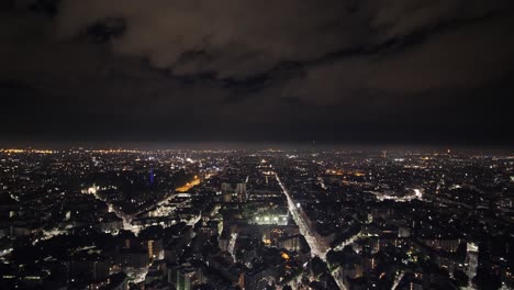 Glowing-lights-of-night-Milan-city,-aerial-view
