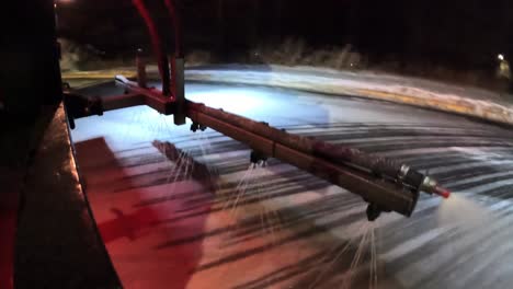 De-ice-truck-spraying-de-ice-fluid-on-public-parking-lot-road-during-winter