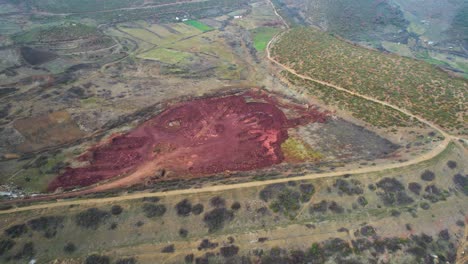 Abandoned-mineral-on-open-pit-filled-with-iron-ore,-danger-red-contaminated-area