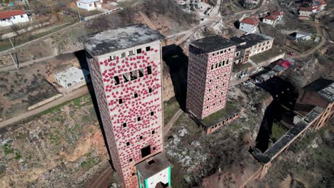 High-towers-of-abandoned-mineral-treatment-factory-with-painted-walls-in-Perrenjas,-Albania