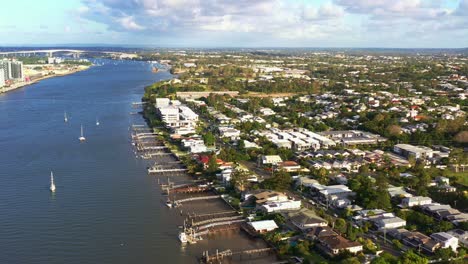 Aerial-view-tilt-down-along-the-bank-capturing-Bulimba-residential-neighborhood,-riverside-homes-with-slipway-and-jetty,-boats-moored-on-the-water,-Brisbane,-Queensland,-Australia