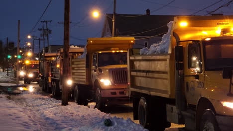 Military-Snow-Dump-Trucks-Lined-In-The-Street-With-Blinking-Lights-In-Buffalo,-New-York,-USA