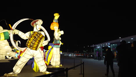Menschen,-Die-Nachts-An-Beleuchteten-Displays-Auf-Dem-Gwanghwamun-Platz-Vorbeigehen