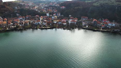 Tourist-village-of-Lin-in-Albania-on-beautiful-peninsula,-reflecting-houses-on-shore-of-Ohrid-lake