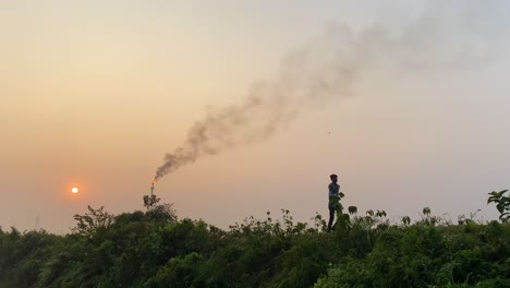 Human-and-pollution-concept,-man-exercising-near-industrial-area,-static,-sunset