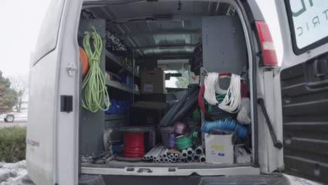 Back-of-white-electrician-service-van-with-industrial-equipment,-nobody