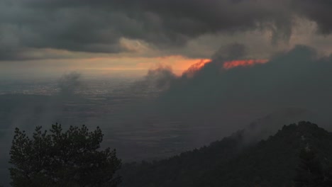 Timelapse-of-clouds-moving-and-sun-rising-in-sky-over-mountain-range