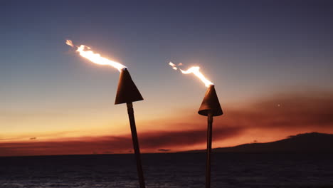Tiki-Torches-Against-Sunset-Sky-At-The-Beach-In-Wailea,-Maui,-Hawaii