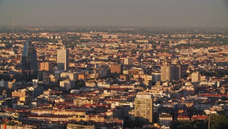 Sun-shining-on-Milan-city-skyline,-view-from-above
