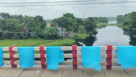 Dyed-fabrics-dry-outdoors-draped-over-a-bridge