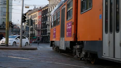 Vintage-tramway-passing-on-street-of-Milan-downtown,-handheld-view