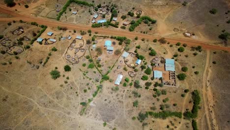 Aerial-drone-view-of-the-arid-region-of-Karamoja,-Uganda-where-there-are-traditional-and-modern-houses,-on-a-sunny-day