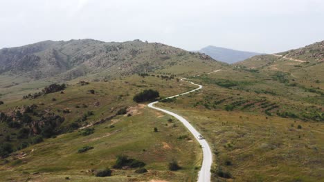 Coche-Blanco-Conduce-Por-Un-Camino-Ligero-Entre-La-Naturaleza-Verde-Del-Norte-De-Macedonia-En-Un-Día-Soleado