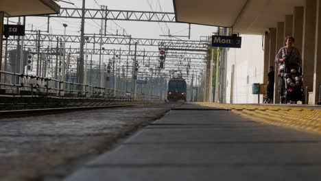 Old-Italian-train-coming-towards-station,-low-angle-static-view